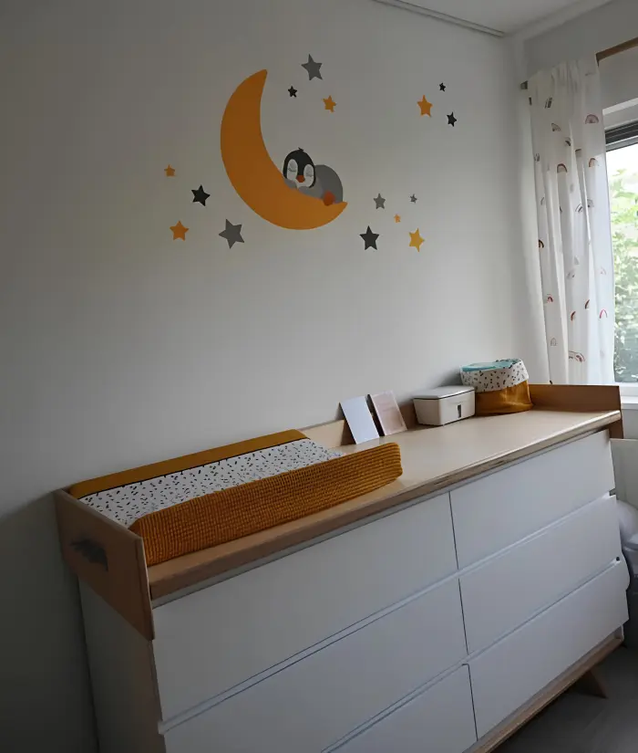 Okergele babykamer met pinguin op de maan behangsticker